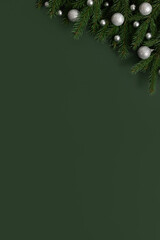Christmas green background with fir branches and silver baubles. Happy new year. Space for text....