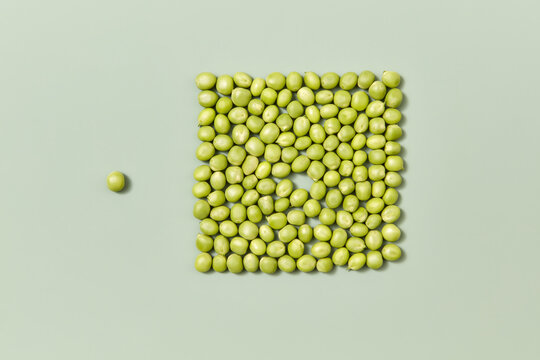 Green beans in form of square, one pea is apart.