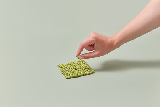 Peas in form of square, woman taking one bean.