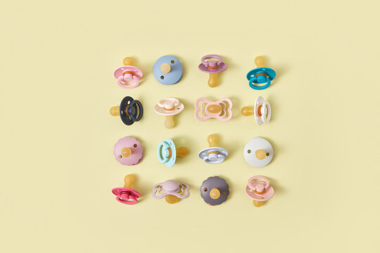 Colorful pacifiers laid out in shape of square.