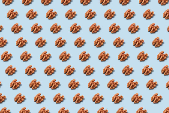 Pattern of walnut kernels on blue background.