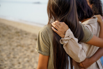 Fototapeta premium Arms wrapping around friends while at the beach