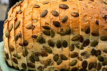 sliced white bread loaf encrusted with pumpkin seeds, sunflower seeds, sesame seeds, poppy seeds - 532550626