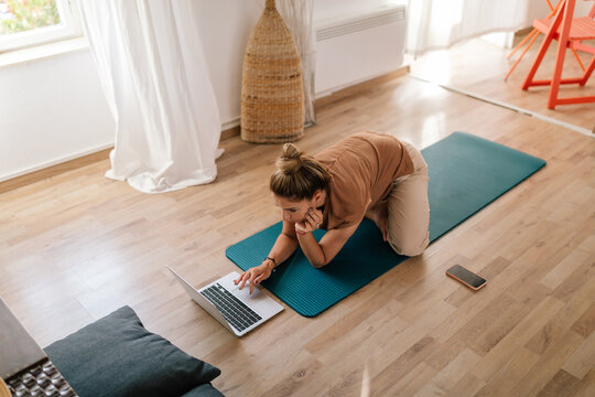 Woman Preparing To Follow An Online Yoga Class On Her Laptop