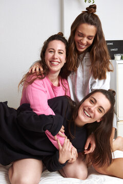  women laughing at bed
