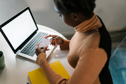 Black woman making online purchase on laptop