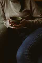 Earthenware cup with matcha tea in hands - 532553411