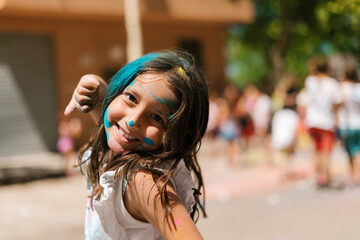 Happy girl celebrating Holi festival on street