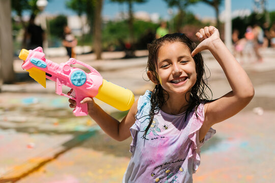 Cheerful girl with water pistol on street