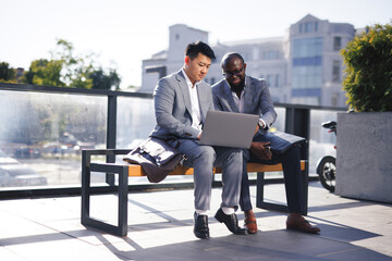Businessman assisting man with business task 