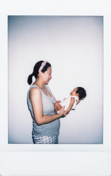 Polaroid photo of young mother holding her newborn baby