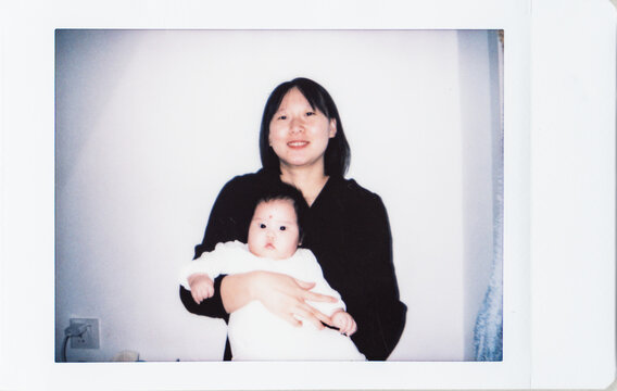 Polaroid photo of young mother holding her newborn baby