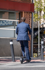 Young executive Businessman Riding Electric Scooter in a street In The City. Arriving late to the office