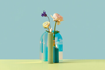 Candles with creative vase with beautiful flowers.