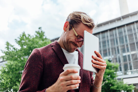 Man with Coffee and Digital Tablet Outdoors