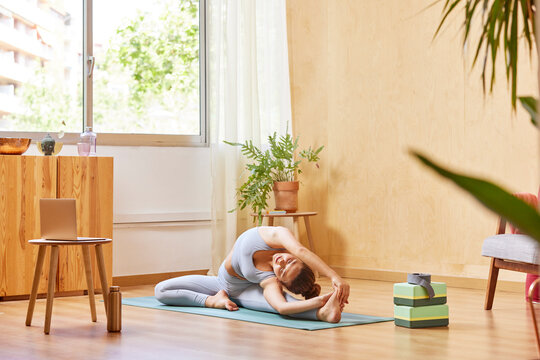 Fit woman doing Revolved Head to Knee asana