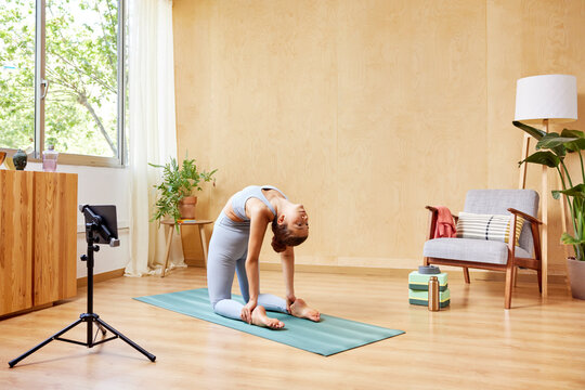 Woman doing Camel asana at home