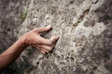 Adult male handholding on to a rock