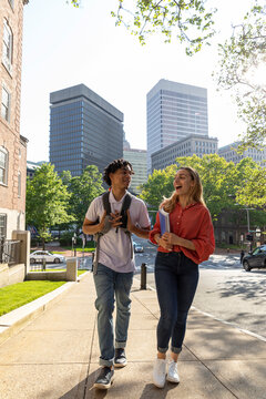Two cute Friends University Students walking on spring day