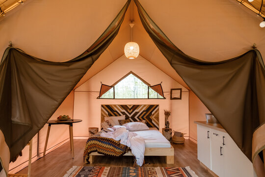 Unmade bed inside glamping tent