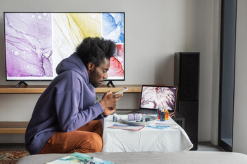 Black artist taking photo at home