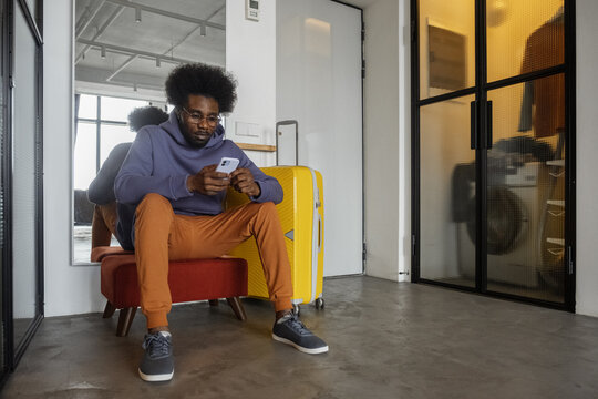 Black man using cellphone before trip