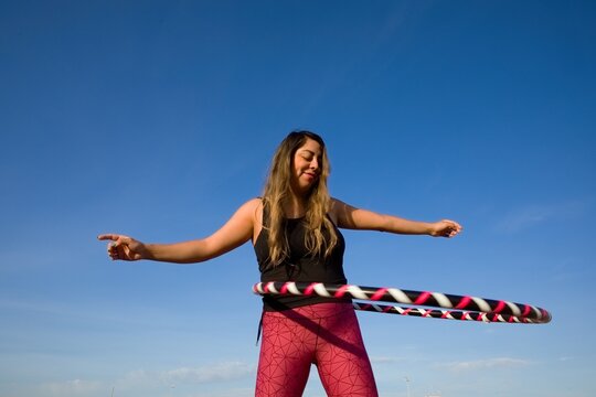 woman exercising with a hula hoop in a natural setting