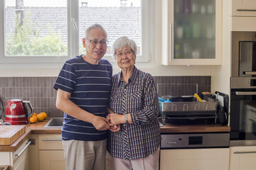 mature senior asian couple portrait looking at camera at home
