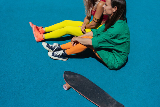 Girls in bright sportswear are relaxing on the sports field.