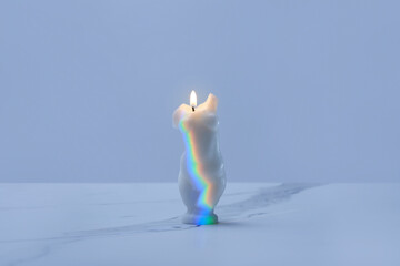 Burning candle with incident rainbow.