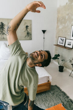 Smiling Young Man Doing Yoga At Home
