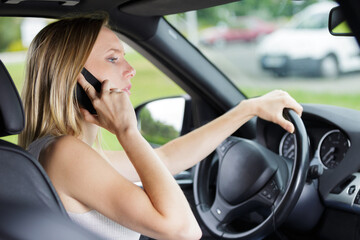Fototapeta na wymiar woman talking on cellphone while driving