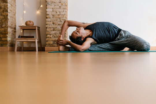 Flexible man practicing Seated gate asana