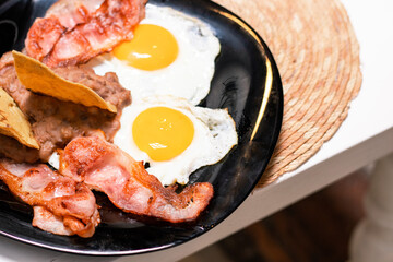 Huevos estrellados con tocino, huevo y frijoles con totopos 