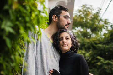 Loving latino couple hugging with pensive/sad expression