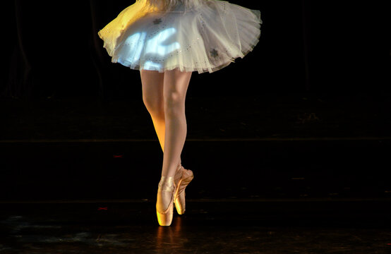 Ballerina From The Waist Down Toe Dancing Against A Black Background