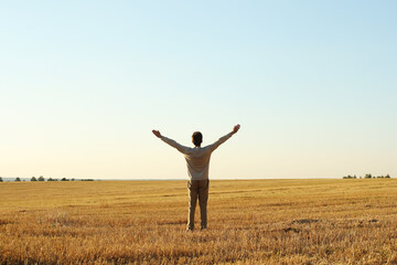 Young man with raised hands in the autumn meadow on a blue clean sky background. Pavel Kubarkov, landscape with blue sky, meadow and i. Photo was taken 10 September 2022 year, MSK time in Russia. - 532564892