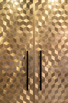 Closeup view at glossy golden doors with geometric pattern