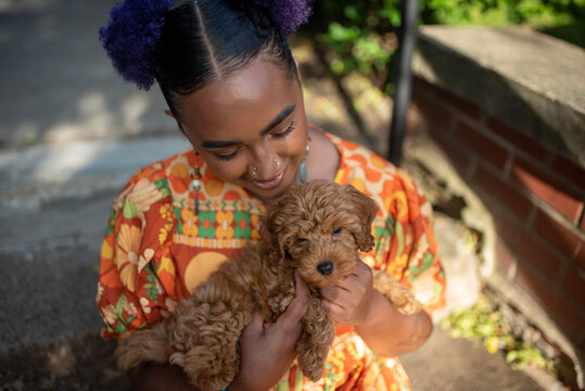A non binary model posing with their puppy 