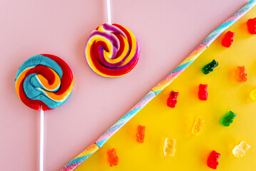 colored lollipops and candies on a pink and yellow background
