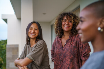 Two friends smiling and looking at girlfriend fondly