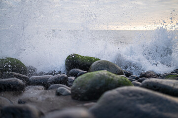 Fototapeta na wymiar Atlantikwellen spitzen über die Steine an der Küste der Azoren