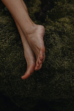 Close up photo of woman's feet on the moss