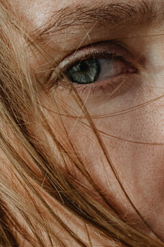 Close Up woman's portrait with grey sad eyes and blonde hair c
