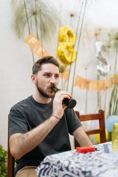 Man having a beer at a backyard party 