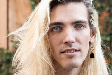 Portrait of young man with long hair outdoors