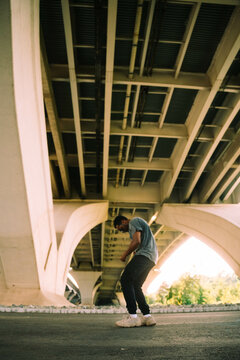 A Dancer Poses Beneath A Bridge In The City