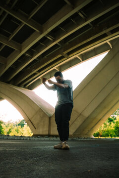 A Dancer Poses Beneath A Bridge In The City