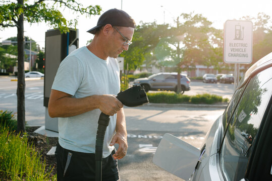 Man holding EV charging connector