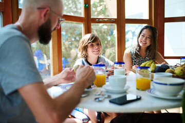 Father, mother and their adopted son in healthy breakfast at home